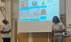 Johnoi and colleague delivering a talk
